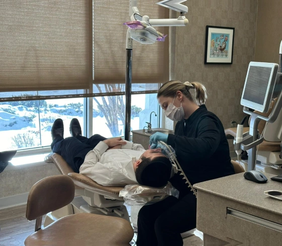 Orthodontist examining patient in dental chair at Parker Orthodontics office with modern equipment visible.